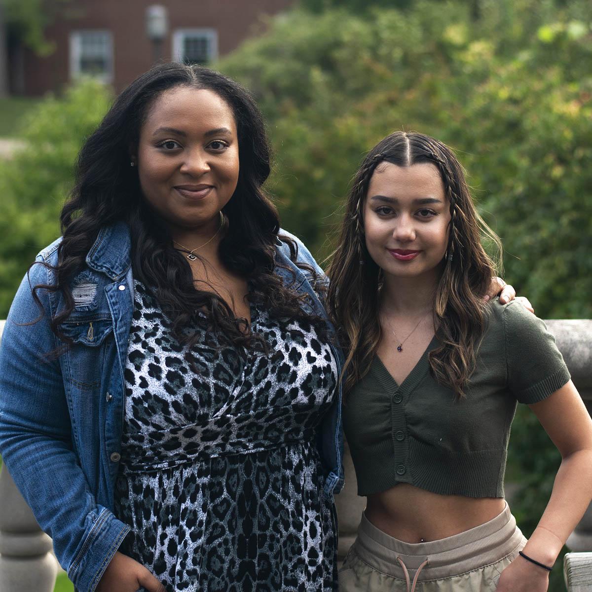 Photo of two young women, one success coach and one first-year student, pose and smile for a photo